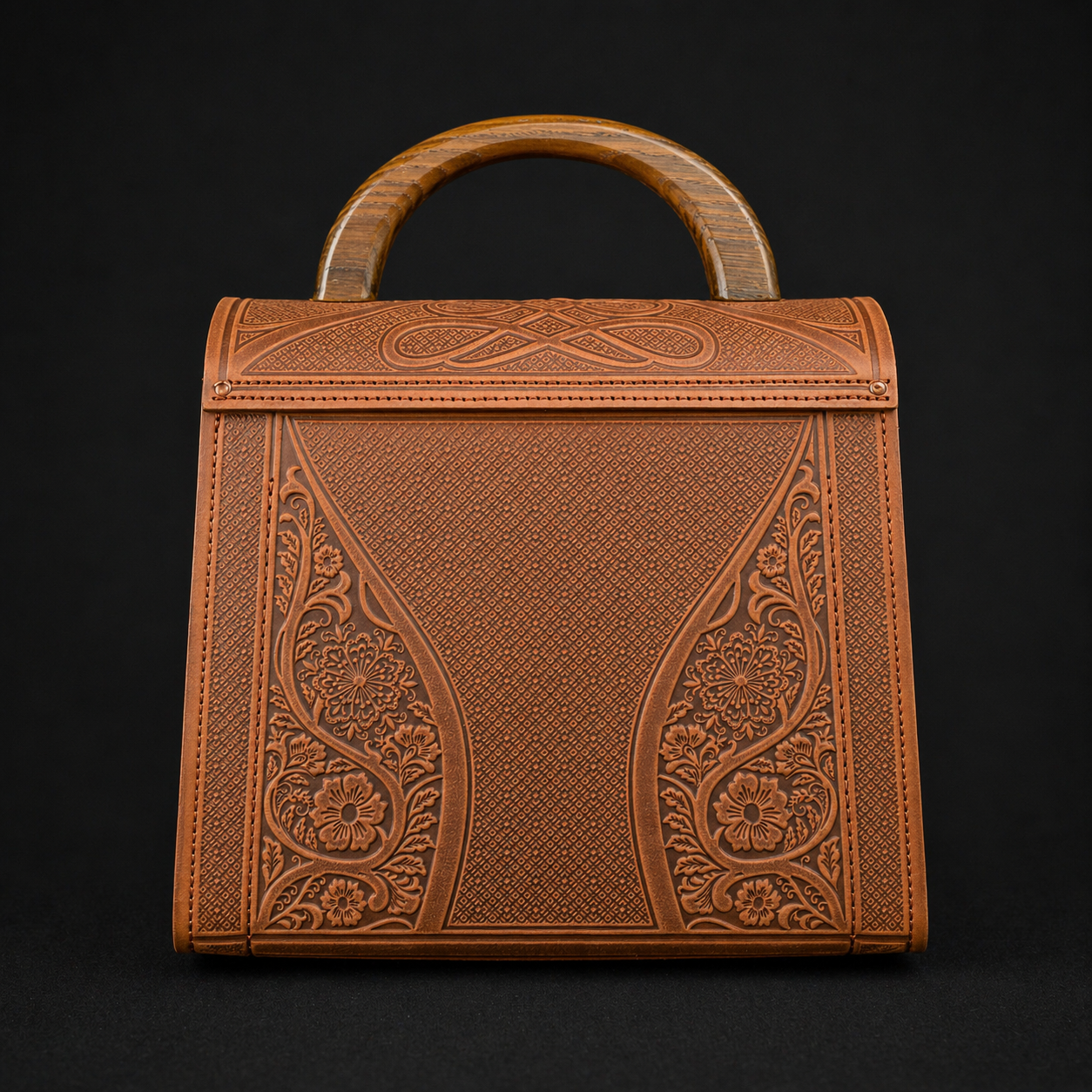 Brown leather handbag with intricate patterns on a black background