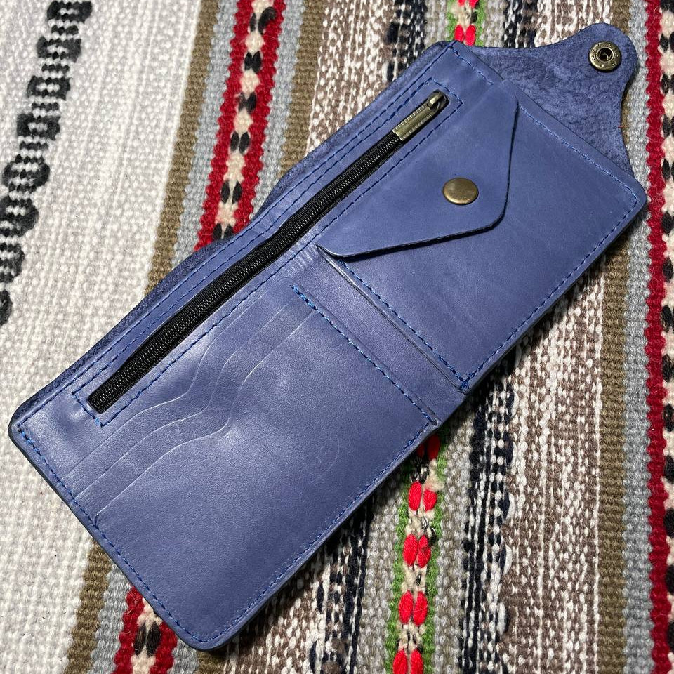 Blue wallet with a zipper on a patterned fabric background