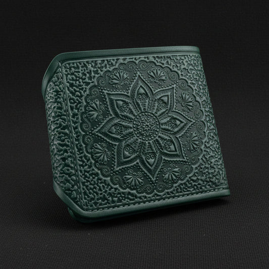 Green embossed wallet with mandala design on a black background