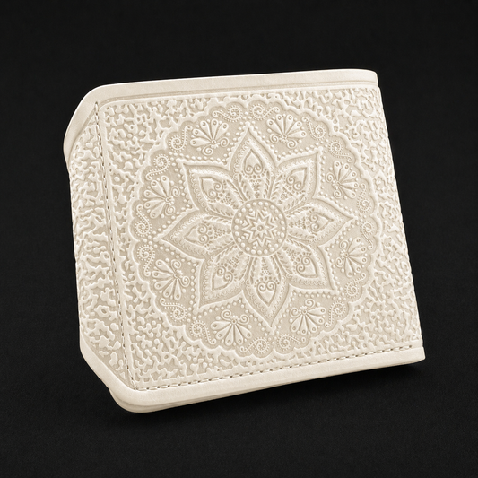 Ivory embroidered wallet with intricate patterns on a black background