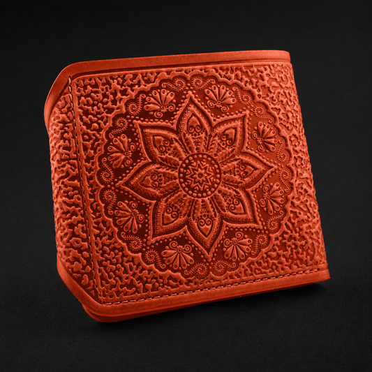 Russet leather wallet with intricate floral embossing on a black background