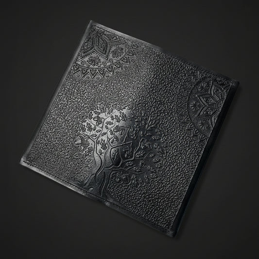 Decorative black leather wallet with embossed tree design on a dark background