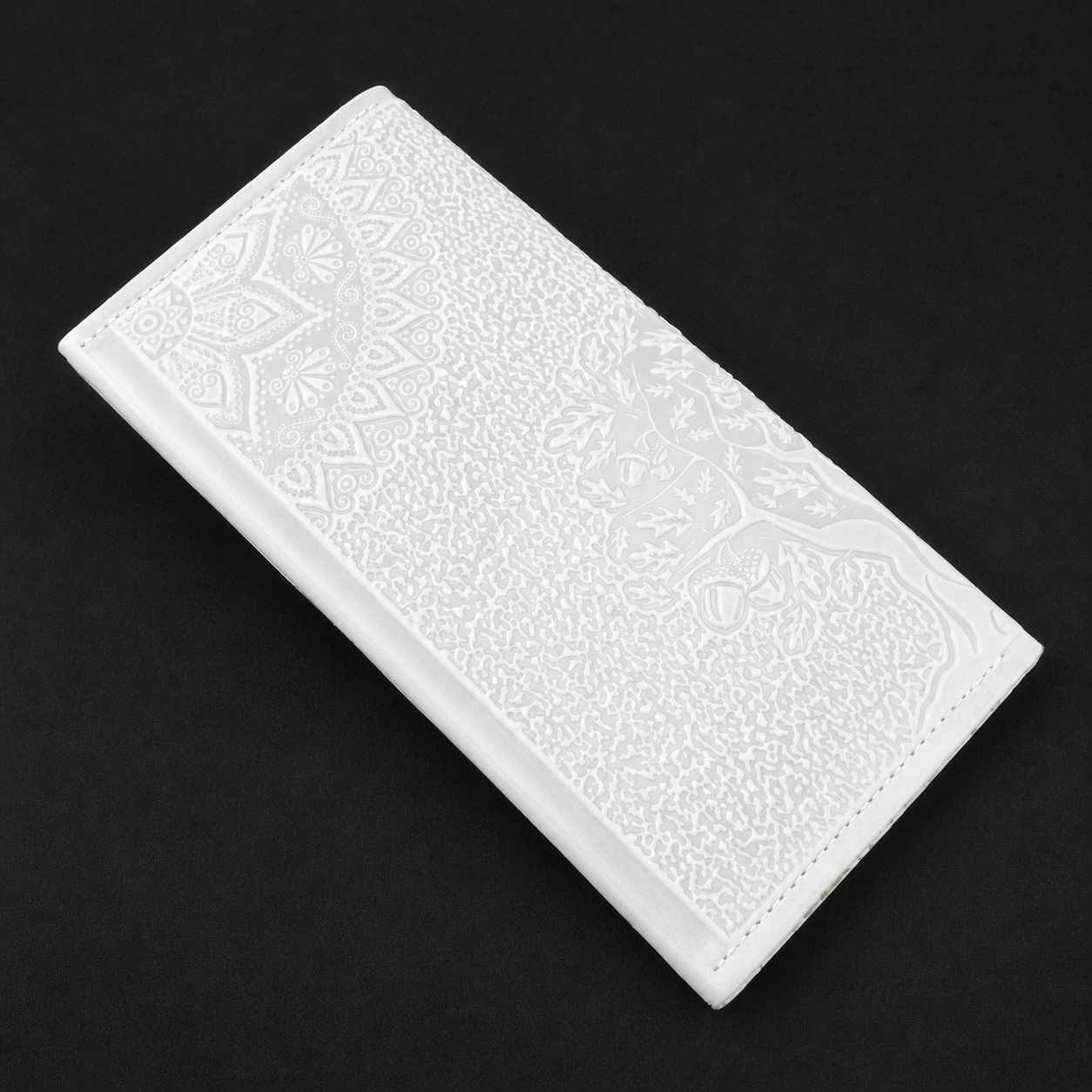 White rectangular tile with embossed pattern on a black background