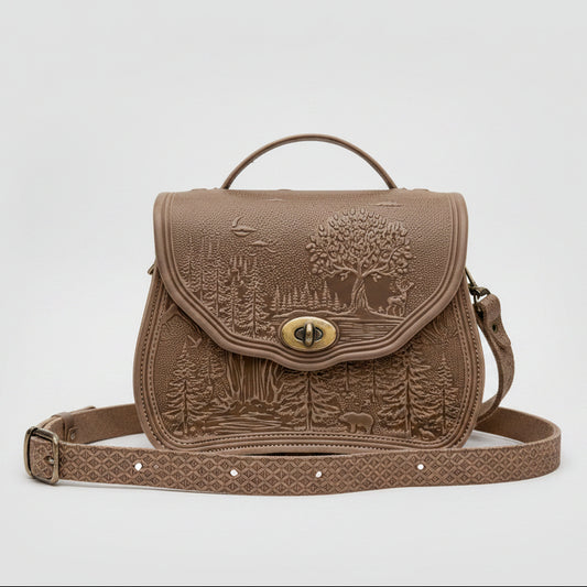 Beige embossed bag on a stone surface with a scenic background