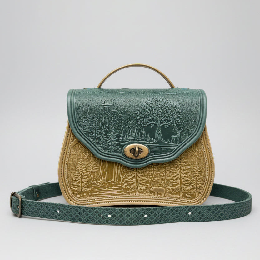 Green and gold embossed leather bag with nature-themed design on a white background