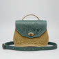 Green and gold embossed leather bag with nature-themed design on a white background