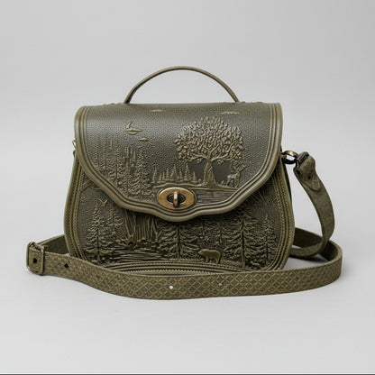 Green leather bag with nature-themed design in a garden setting