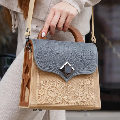 Person holding a decorative handbag with intricate patterns