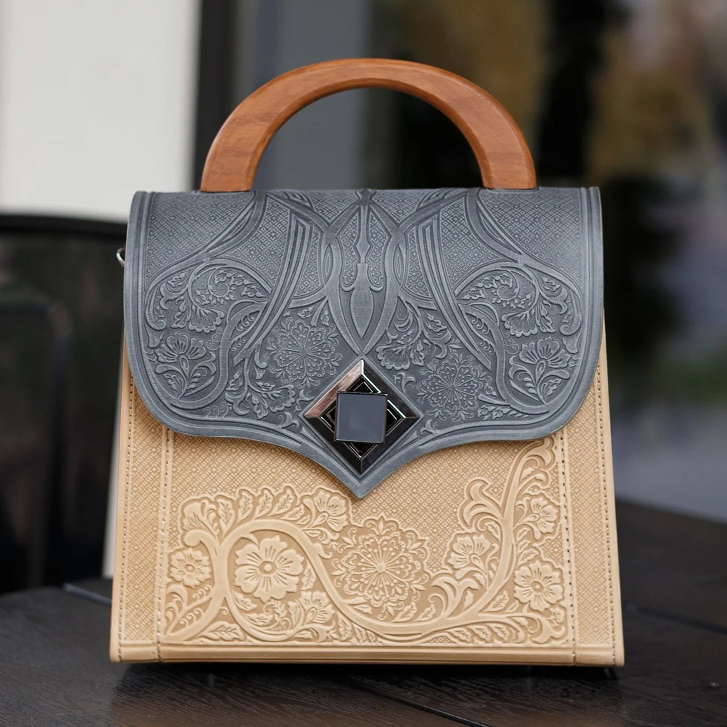 Handbag with embossed design on a dark surface
