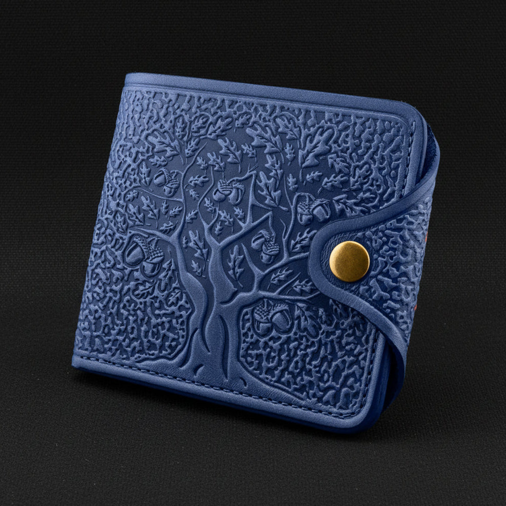 Blue embossed wallet with a gold button on a black background