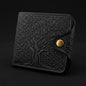 Black embossed wallet with a gold button on a light gray background