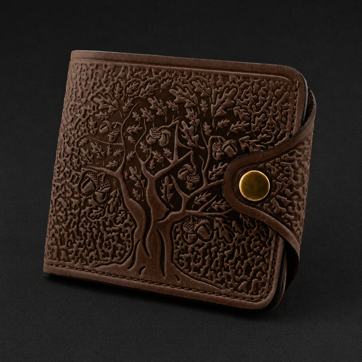 Brown leather wallet with embossed design on a black background