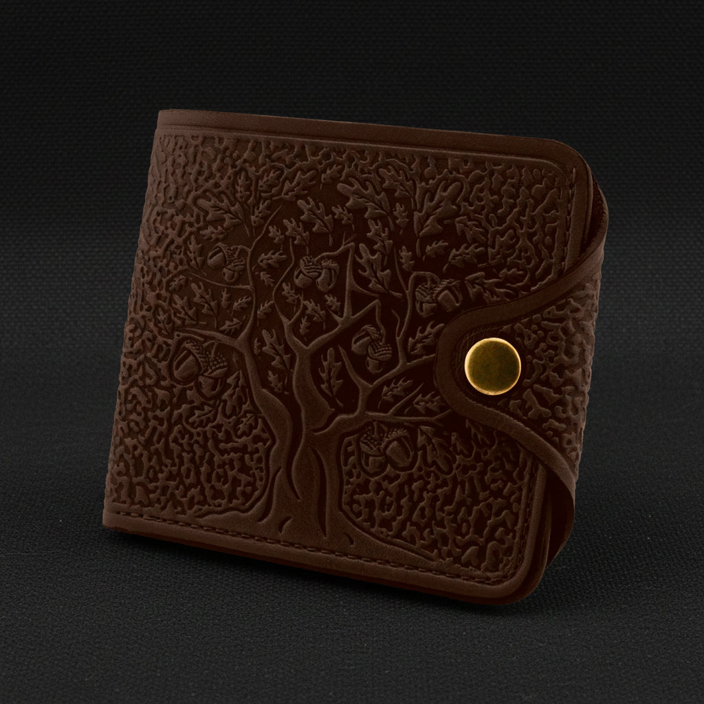 Brown leather wallet with embossed design on a black background