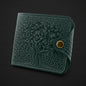 Green textured wallet with a gold button on a black background