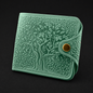 Green textured wallet with tree design on a black background