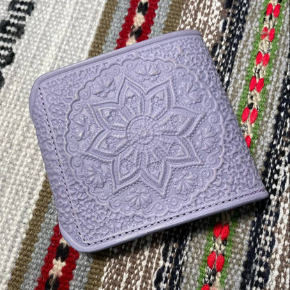 Purple embossed wallet on a patterned fabric background