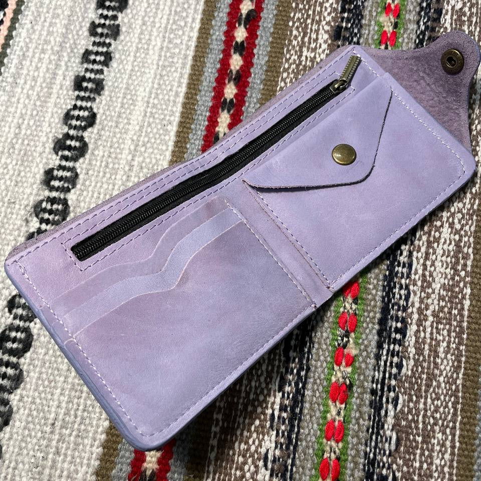 Purple wallet with a zipper on a patterned fabric background