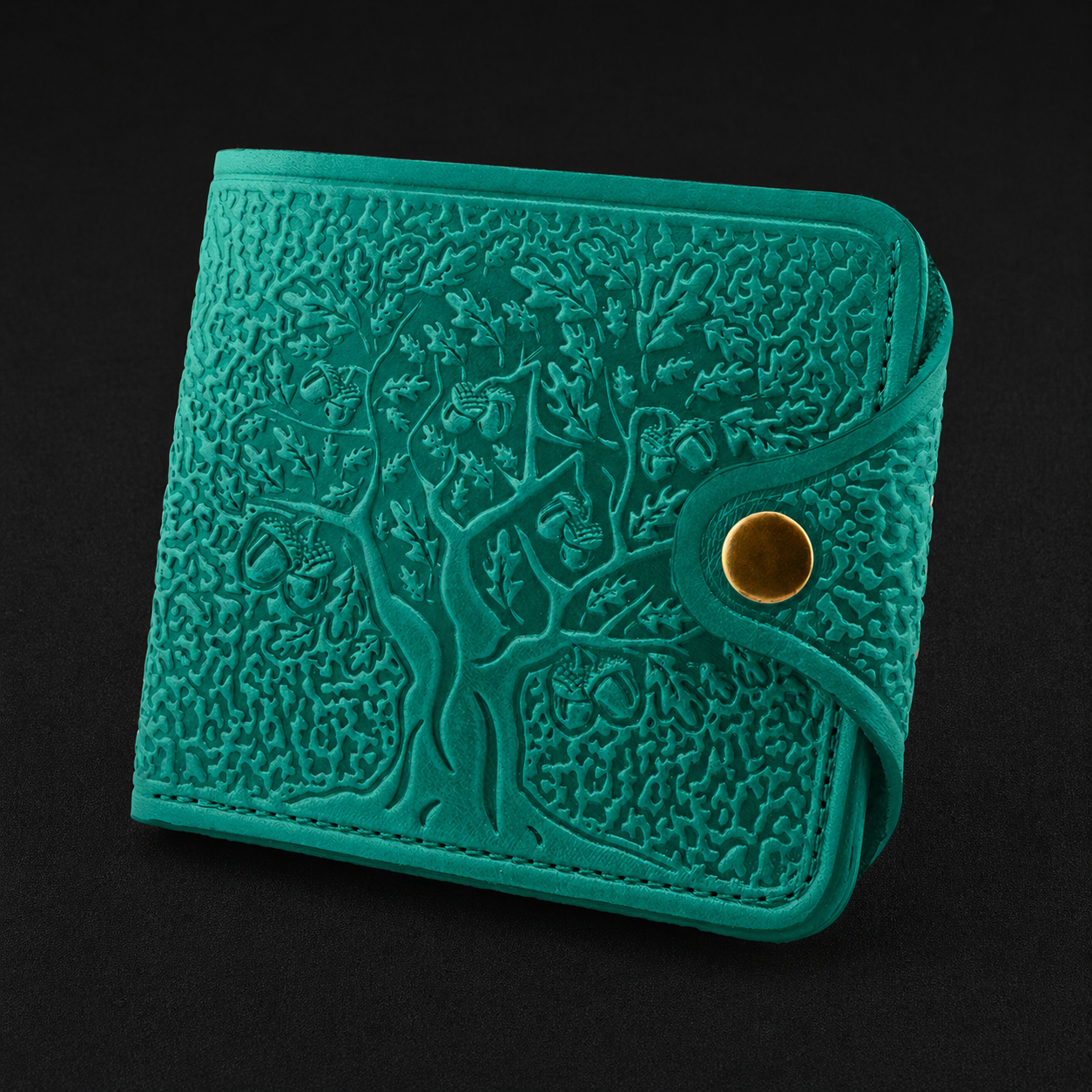 Teal textured wallet with a gold button on a black background