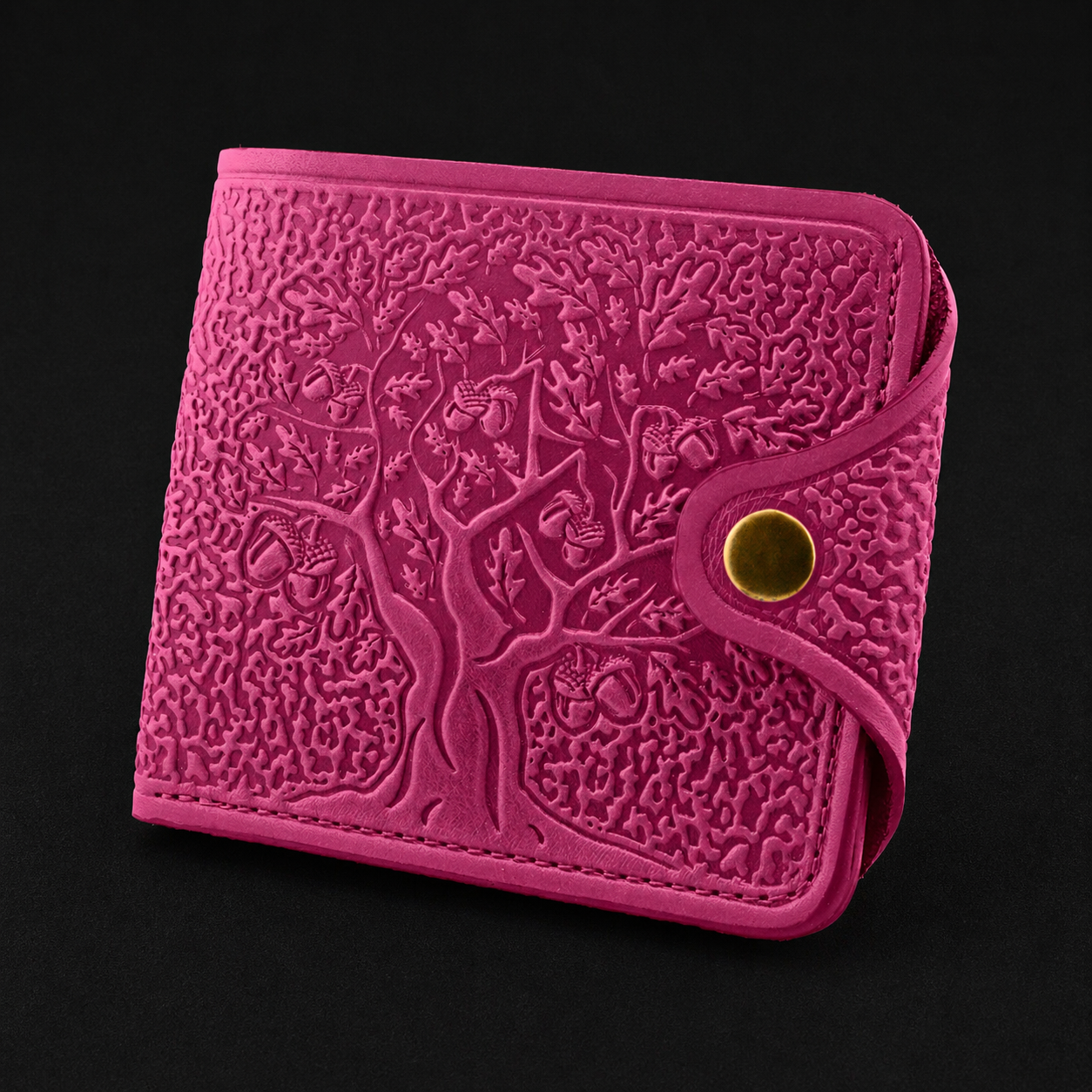 Pink embossed wallet with tree design on a black background