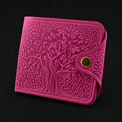 Pink embossed wallet with tree design on a black background