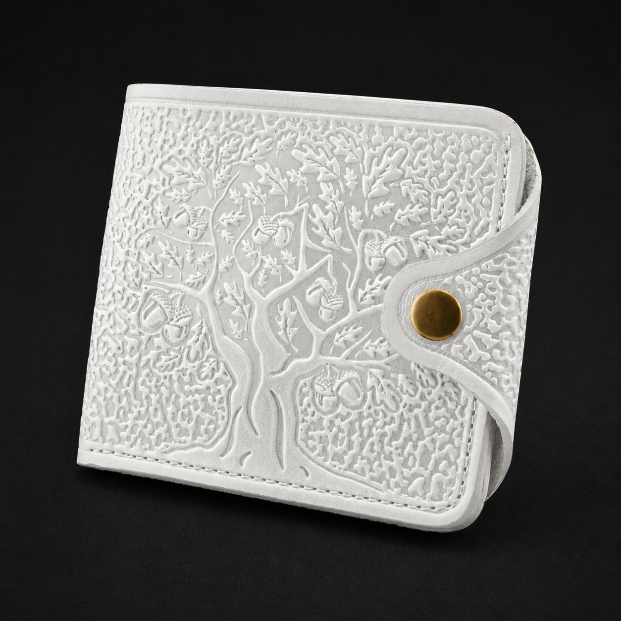 White embossed wallet with a gold button on a black background