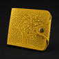 Yellow embossed wallet with tree design on a black background