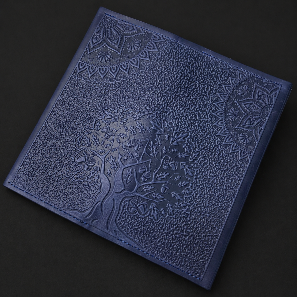 Blue textured wallet with embossed design on a black background