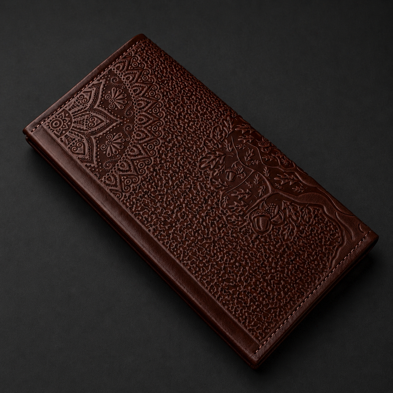 Brown leather wallet with intricate patterns on a dark background