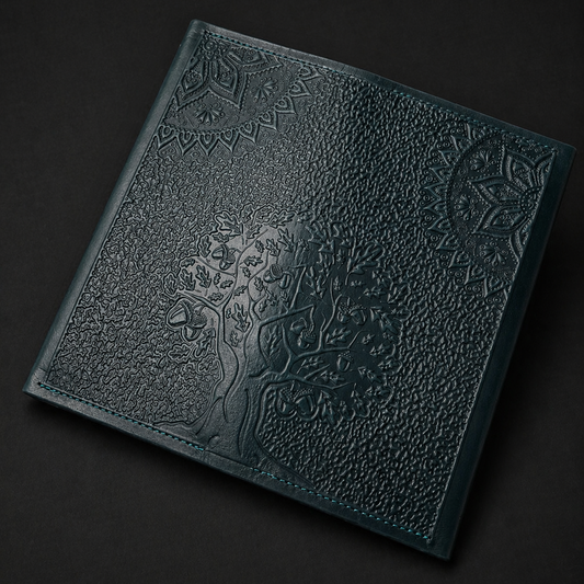 Dark green leather-bound book with embossed design on a black background