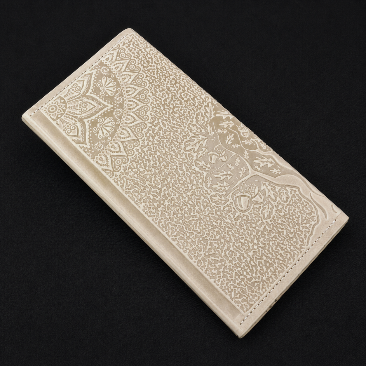 Ivory wallet with embossed patterns on a black background