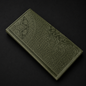 Green embossed leather wallet on a black background