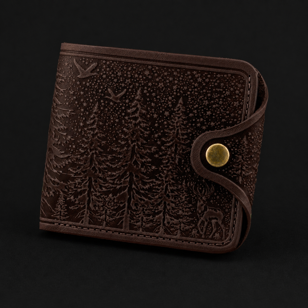 Burgundy leather wallet with forest design and gold button on a black background