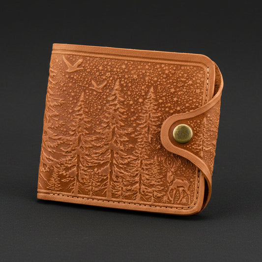 Brown leather wallet with forest design on a black background