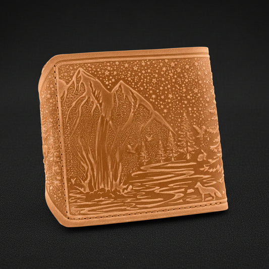 Brown leather wallet with mountain and forest design on a black background