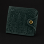 Green textured wallet with a gold button on a black background