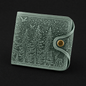 Gray leather wallet with forest design on a black background