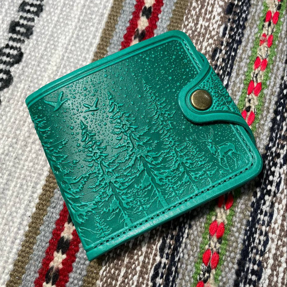 Green textured wallet with a gold clasp on a patterned fabric background