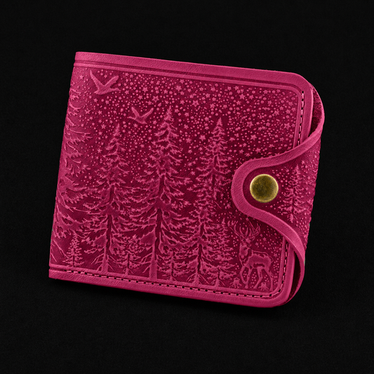 Pink wallet with embossed design on a black background