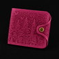 Pink wallet with embossed design on a black background