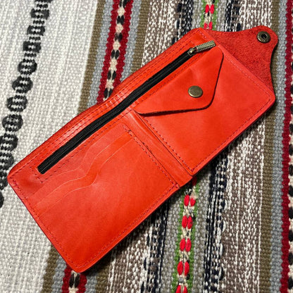 Red leather wallet on a patterned fabric background