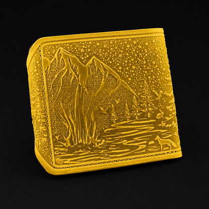 Gold-colored wallet with mountain and landscape design on a black background