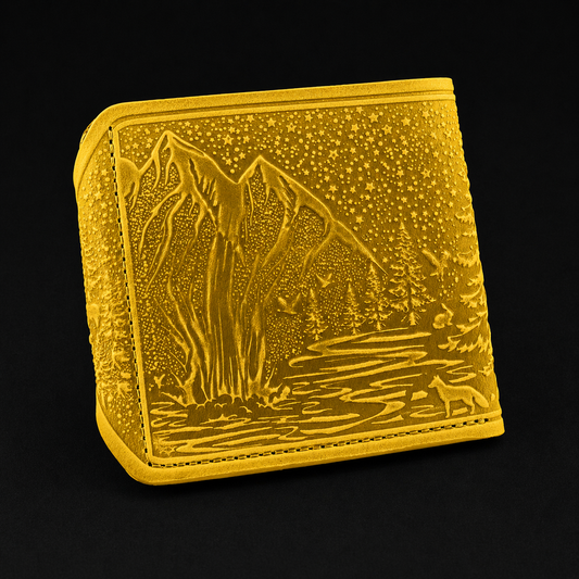 Gold-colored wallet with mountain and landscape design on a black background